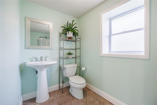 bathroom with baseboards, tile patterned floors, and toilet