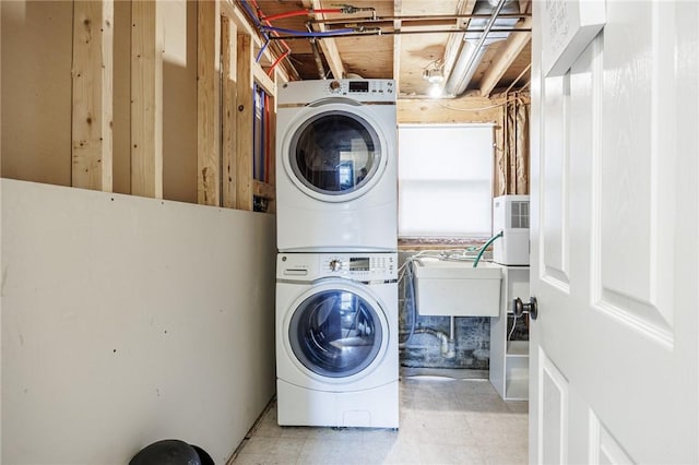 clothes washing area featuring laundry area, a sink, and stacked washer / drying machine