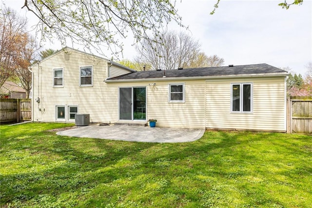 rear view of house with a yard, a patio, a fenced backyard, and central air condition unit