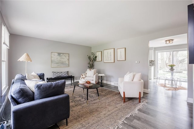 living area with baseboards and wood finished floors