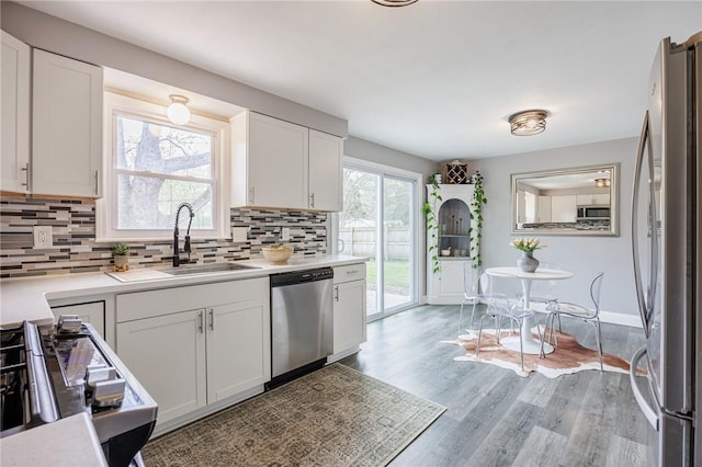 kitchen featuring light countertops, a sink, tasteful backsplash, and stainless steel appliances