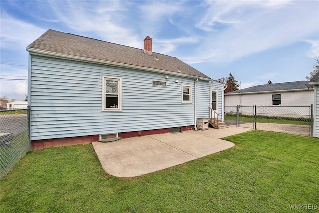 back of property with a lawn, a fenced backyard, and entry steps