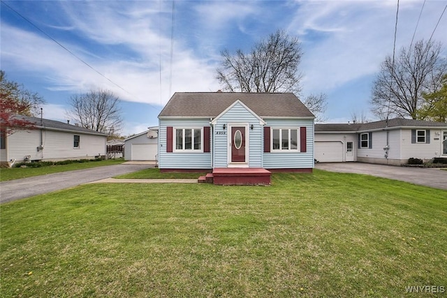 view of front facade featuring a detached garage and a front lawn