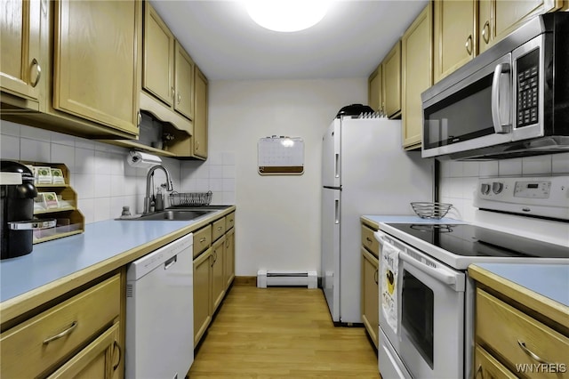 kitchen featuring a sink, backsplash, baseboard heating, and white appliances