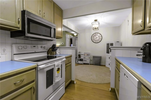 kitchen with white appliances, baseboards, light wood-type flooring, light countertops, and tasteful backsplash