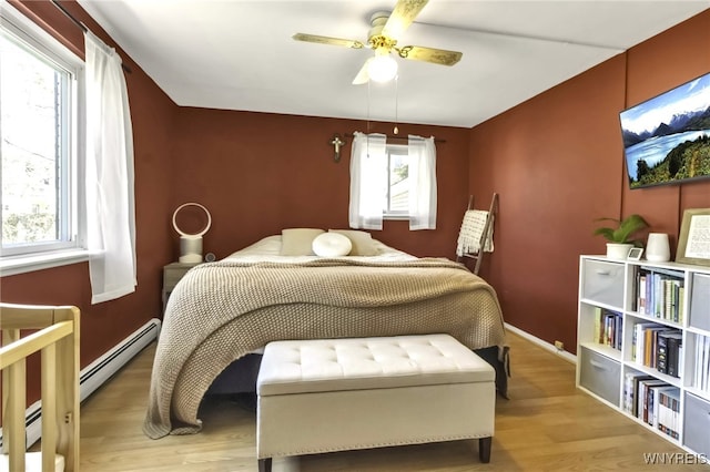 bedroom with baseboards, a ceiling fan, a baseboard heating unit, and wood finished floors