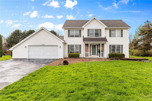 view of front of property with an attached garage, a front yard, and aphalt driveway