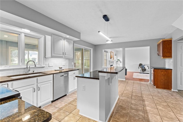 kitchen with light tile patterned flooring, white cabinetry, tasteful backsplash, a sink, and dishwasher