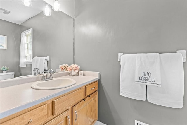 bathroom featuring visible vents, toilet, and vanity