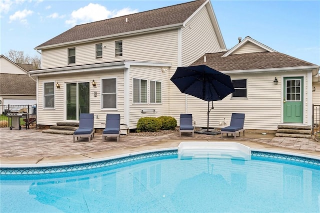 back of property featuring fence, a patio area, entry steps, and an outdoor pool