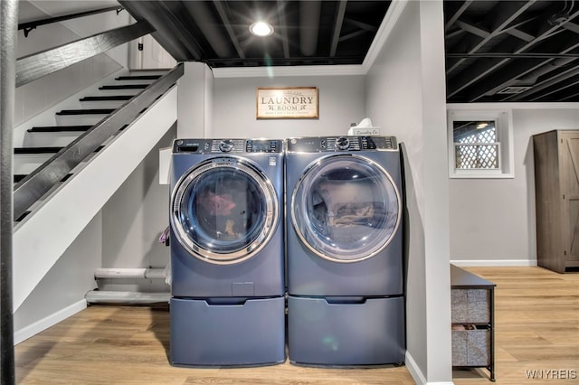 laundry room with baseboards, washer and clothes dryer, and wood finished floors