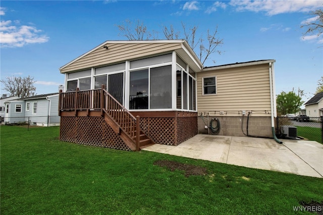 back of house with fence, a sunroom, central AC unit, a patio area, and a lawn