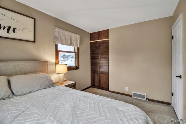 bedroom with baseboards, a closet, carpet flooring, and visible vents