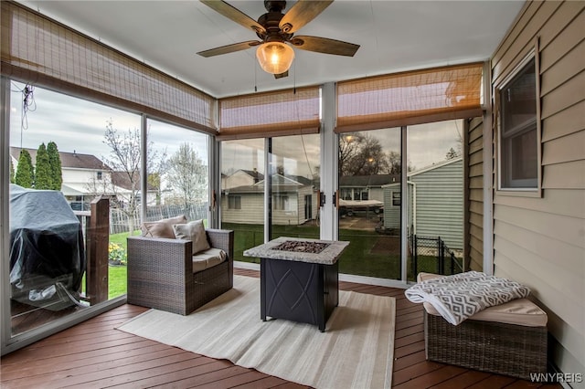 sunroom with ceiling fan and an outdoor fire pit