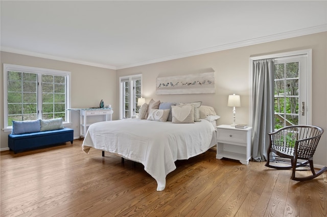 bedroom with crown molding, baseboards, wood finished floors, and access to exterior