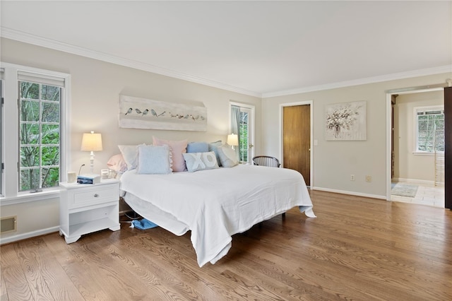 bedroom with crown molding, baseboards, visible vents, and wood finished floors