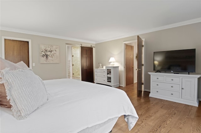 bedroom featuring baseboards, ornamental molding, wood finished floors, and ensuite bathroom