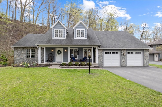 cape cod house with a garage, a front yard, driveway, and stone siding