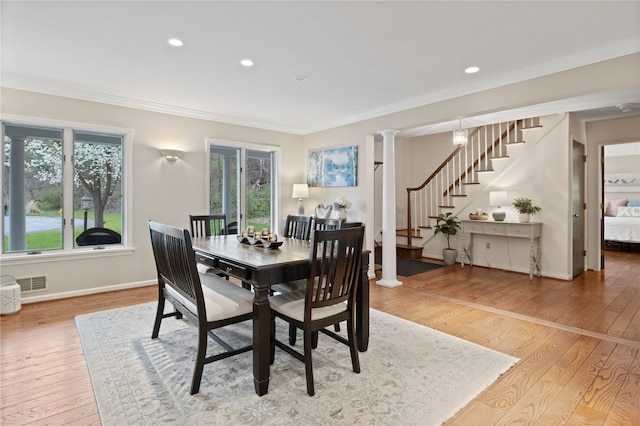 dining room with light wood-style floors, ornamental molding, stairs, and visible vents