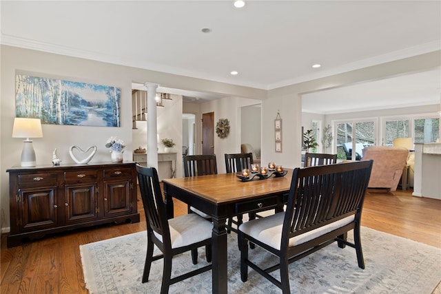 dining area featuring crown molding, recessed lighting, decorative columns, and wood finished floors