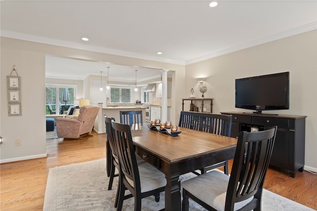 dining room with crown molding, recessed lighting, and light wood-type flooring