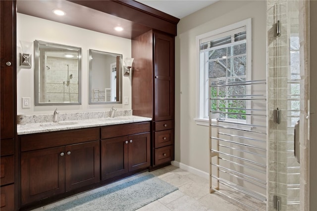 bathroom featuring baseboards, a sink, and a shower stall