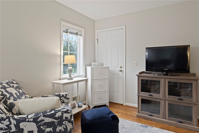 sitting room with baseboards and wood finished floors