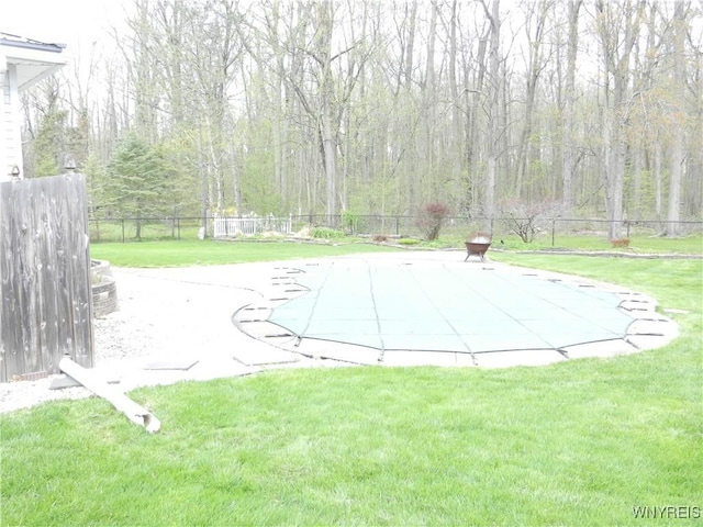 view of swimming pool featuring a lawn and a fenced backyard