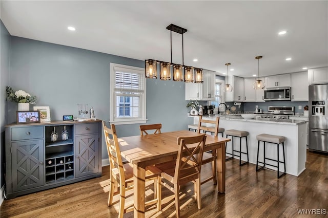 dining space with dark wood-style flooring, recessed lighting, and baseboards