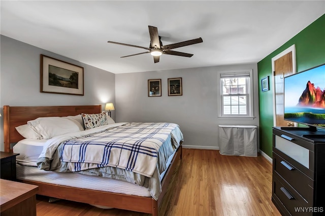 bedroom with a ceiling fan, baseboards, and wood finished floors