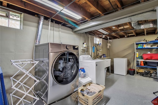 laundry room featuring a healthy amount of sunlight, laundry area, washing machine and dryer, and a sink