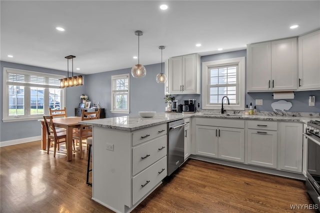 kitchen with a sink, a peninsula, dark wood-style floors, stainless steel appliances, and recessed lighting