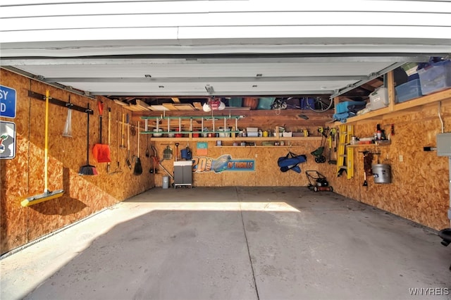 garage featuring a workshop area and wood walls