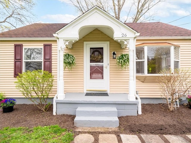 doorway to property with a shingled roof