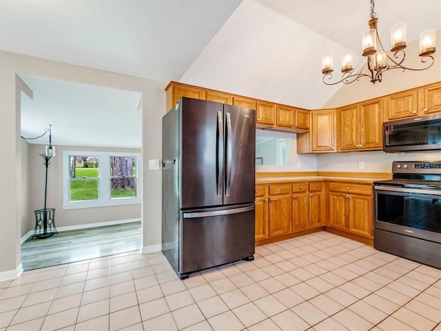 kitchen with vaulted ceiling, light tile patterned floors, light countertops, an inviting chandelier, and stainless steel appliances