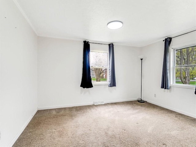 empty room with baseboards, plenty of natural light, carpet, and visible vents