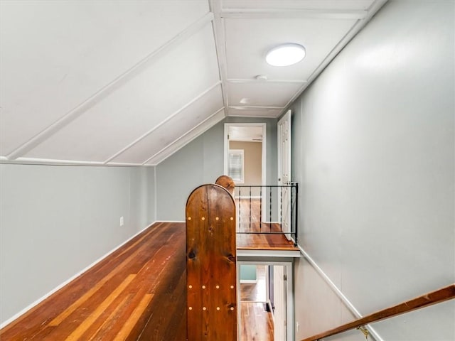hall with vaulted ceiling and wood finished floors