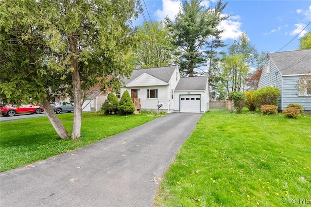view of front facade with an attached garage, aphalt driveway, and a front yard