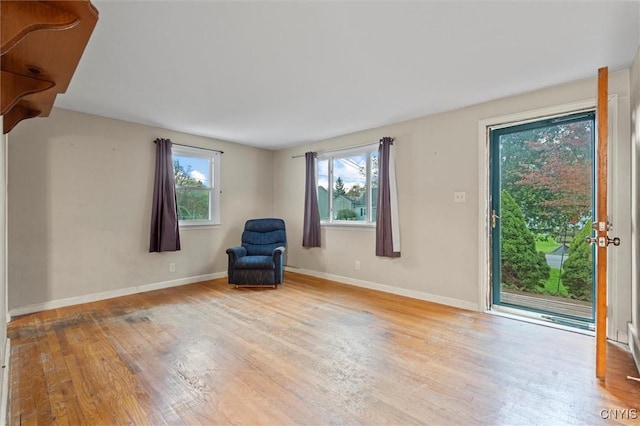 unfurnished room with plenty of natural light, baseboards, and wood finished floors