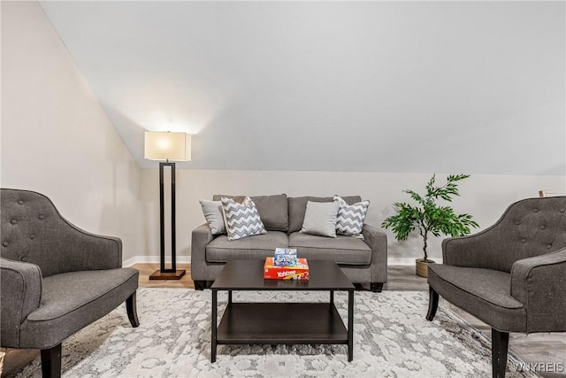 living area with light wood-style floors, baseboards, and lofted ceiling