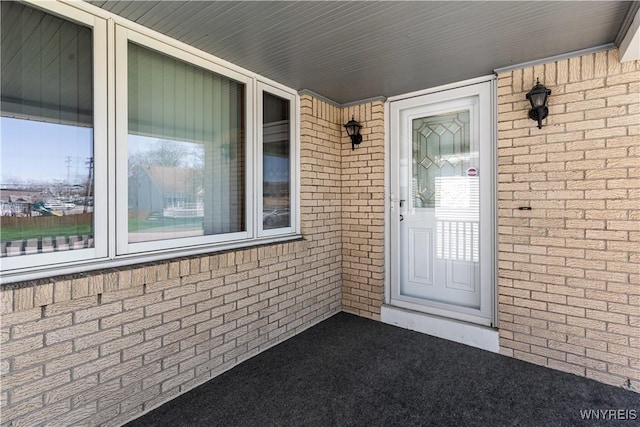 doorway to property featuring brick siding