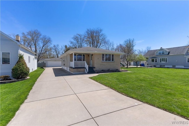 bungalow-style home featuring brick siding, a front lawn, an outbuilding, and a detached garage