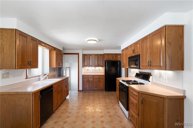 kitchen with a sink, light floors, tasteful backsplash, and black appliances