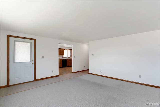 interior space with baseboards, a wealth of natural light, and light colored carpet
