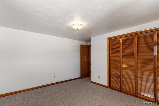 unfurnished bedroom featuring a closet, baseboards, and carpet floors