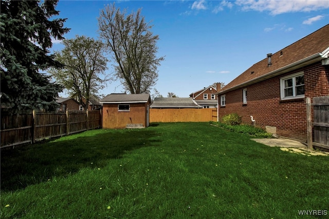 view of yard featuring an outdoor structure, a fenced backyard, and a storage shed