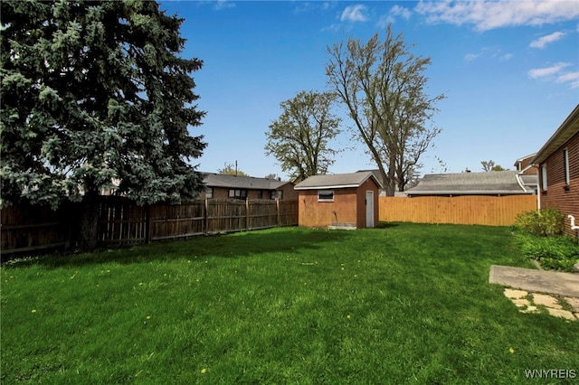 view of yard featuring an outbuilding, a fenced backyard, and a shed