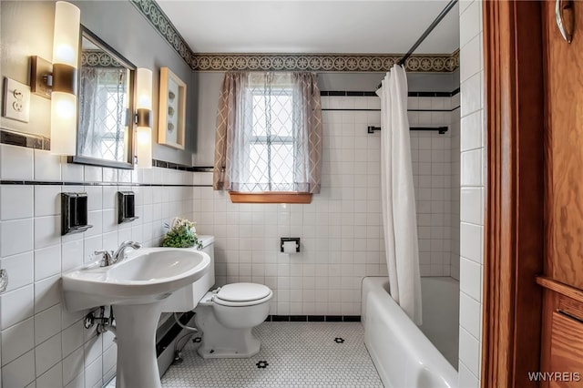 bathroom with tile walls, tile patterned flooring, toilet, and shower / tub combo with curtain