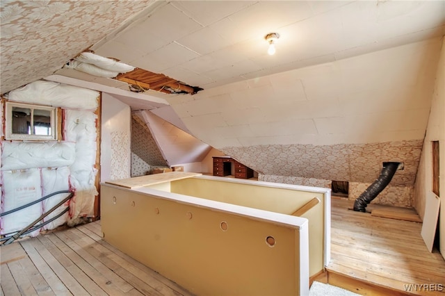 bonus room featuring light wood-style flooring and lofted ceiling