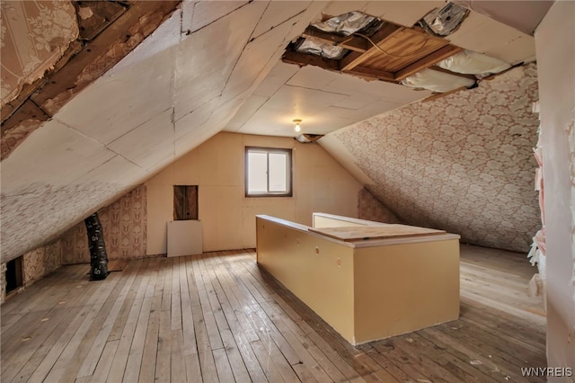 bonus room with vaulted ceiling and hardwood / wood-style flooring